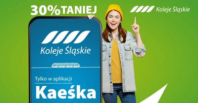 Testuj aplikację kaeśka. Uśmiechnięta młoda kobieta stoi obok ogromnego smartfona. Na ekranie informacja o aplikacji Kaeśka i zniżce 30% na bilety - szczegóły w treści artykułu