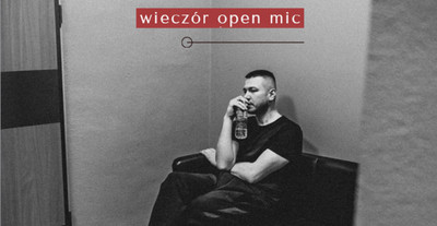 Plakat wydarzenia: Stand-up. Mateusz Socha przedstawia. Wieczór open mic. Mężczyzna siedzący na sofie w pomieszczeniu.